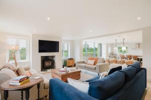 ein Wohnzimmer mit einer blauen Couch und einem Kamin in der Unterkunft Mulberry Cottage - Stunning 5 Bed in Wiltshire! in Charlton