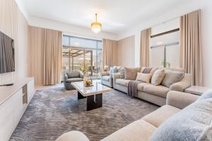 a living room with a couch and a table at Sea Views 4BR and Assistant's Room Villa with Private Pool, Sharm - Al Dana Villa, Al Dana Island by Deluxe Holiday Homes in Fujairah