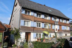 un gran edificio de ladrillo con puertas y ventanas blancas en Ferienwohnung Nina, en Bildstein