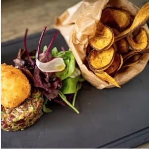 a plate with a sandwich and a salad and chips at Sunset in Saint-Jean-de-Monts
