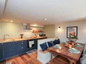Una sala de estar con una mesa y una cocina. en A Stones Throw, en Scarborough