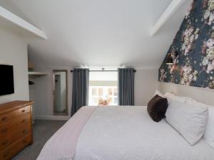Un dormitorio con una cama grande y un televisor. en A Stones Throw, en Scarborough