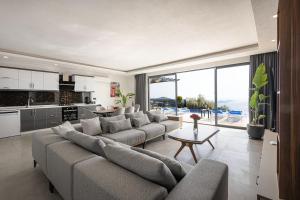 a living room with a large couch and a kitchen at Villa Upper House in Kas