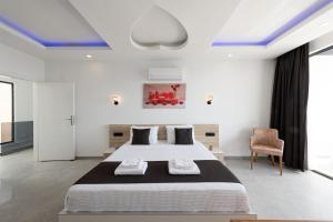 a white bedroom with a large bed and a chair at Villa Upper House in Kas +47 photos