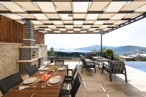 an outdoor patio with a table and chairs and a fireplace at Villa Upper House in Kas