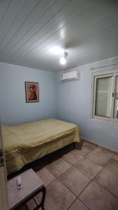a small room with a bed and a window at Casa de campo zona rural- wifi - lareira - in Gravataí