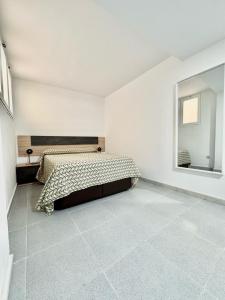 biała sypialnia z łóżkiem i lustrem w obiekcie Apartamento Cabo de Gata w mieście El Cabo de Gata