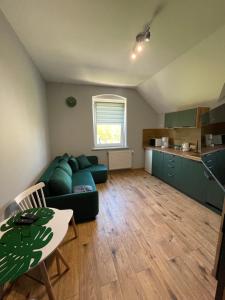 een woonkamer met een groene bank en een tafel bij Przystanek Karpacz - Komuny Paryskiej 3 in Karpacz
