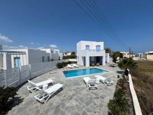 a villa with a swimming pool and lounge chairs at Villa Santorini Serenity with private Pool in Monolithos