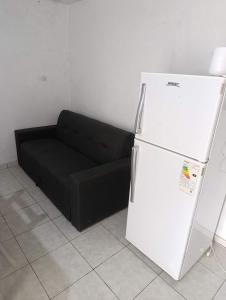 a black couch and a white refrigerator in a room at El ROBLE 2 in Córdoba +2 photos