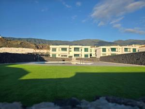 a large field of green grass in front of a building at VV Milenaiver "by henrypole home" in Los Cancajos