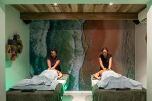 two people sitting on beds in a room at Abalone Hotel & Villas in Paternoster