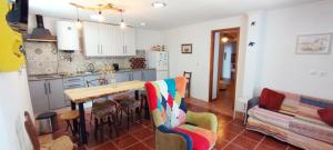 a kitchen and living room with a table and a couch at Casa da Bica in Alvalade