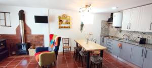 a kitchen with a table and chairs and a stove at Casa da Bica in Alvalade