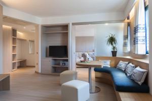 a living room with a couch and a table at Mercure Olbia Hotel e Spa in Olbia