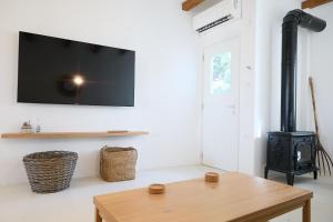 a living room with a wood stove and a tv at Senza's Cycladic Home in Marpissa , Paros in Kampos Paros