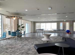 アブダビにあるF1 Dreamstay 1bhk Gym Poolのテーブルと椅子、窓が備わる広い客室です。