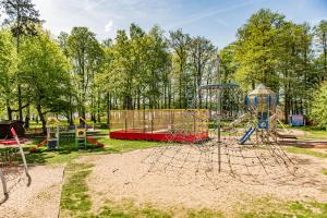 a playground in a park with a play equipment at Apartament w City Park nad jeziorem in Szczecinek