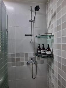 una doccia con tre bottiglie su una mensola in bagno di Stay 801 a Suwon