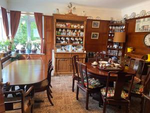 a dining room with a table and chairs and a room with a clock at Cornerways Guest House St Austell Cornwall in St Austell