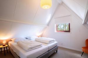 a bedroom with two white beds in a attic at Boshuisje Rekem - Ember in Lanaken +30 photos