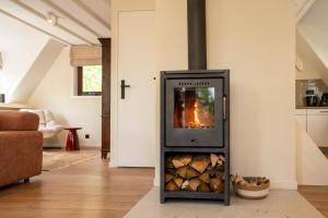 a fireplace in a living room with a stove at Boshuisje Rekem - Ember in Lanaken