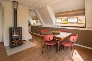 a kitchen and dining room with a wood stove at Boshuisje Rekem - Ember in Lanaken