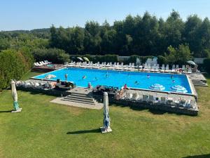 an overhead view of a large swimming pool with people in it at Еко-готель Quiet Forest in Kopystin