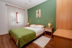 ein Schlafzimmer mit einem Bett mit einer grünen Wand in der Unterkunft Apartment Iva in Pula