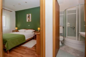 ein grünes Schlafzimmer mit einem Bett und einem Badezimmer in der Unterkunft Apartment Iva in Pula
