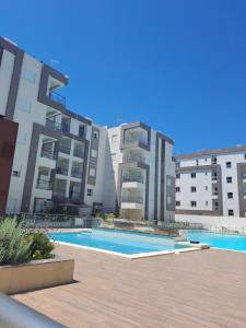 a swimming pool in front of some apartment buildings at La PERLA in Hammamet Sud