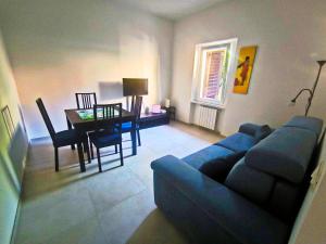 a living room with a blue couch and a table at Modern and quiet apartment in Rome