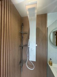 a shower in a bathroom with a wooden wall at Modern 2 Bedroom Home in Kinmel Bay +10 photos