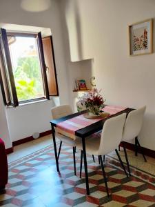 ein Esstisch mit Stühlen und einer Vase mit Blumen in der Unterkunft A casa mia in Santa Maria degli Angeli