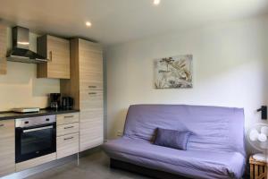a living room with a purple couch in a kitchen at Studio Occitanie 20 m2 tout équipé avec jardin in Muret
