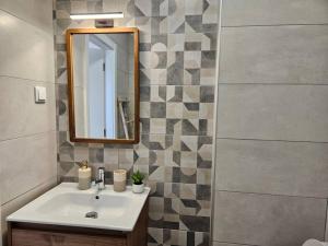 une salle de bain avec un lavabo et un miroir dans l'établissement Apartamento moderno na praia com varanda grande, à Quarteira 20 autres photos