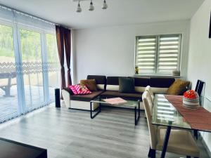 a living room with a couch and a table at Dom Wakacyjny Cztery Pory Roku in Bystra