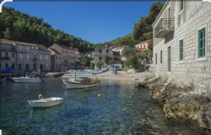 two boats in a body of water next to buildings at Milton holiday house in Blato