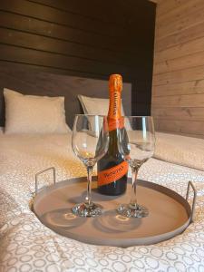 a bottle of champagne and two wine glasses on a tray at Domki Letniskowe Pola in Ryn +23 photos