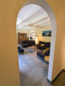 un arco che conduce a un soggiorno con divani e tavoli di Magnifique maison avec piscine, idéalement située a La Teste-de-Buch Altre 23 foto