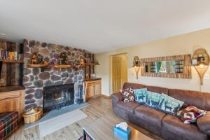 a living room with a couch and a fireplace at Straight Brook 5D - Adirondack-Style Townhome in North Creek