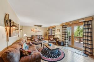 a living room with a couch and a table at Straight Brook 5D - Adirondack-Style Townhome in North Creek +23 photos