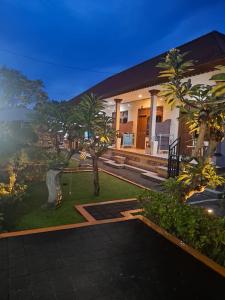 a home with palm trees in the yard at Frangipani Homestay in Nusa Dua