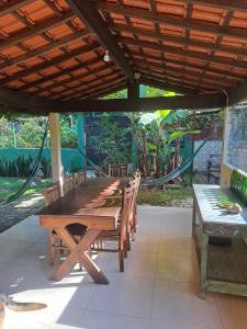 a wooden table and chairs under a wooden roof at Canto da saíra inn in Água Boa
