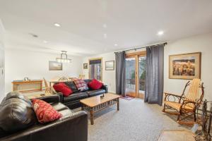 a living room with a leather couch and a table at Tahawus 74I - A Cozy Adirondack Retreat in North Creek +22 photos