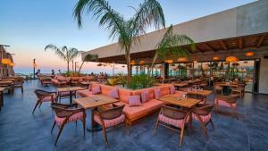 a restaurant with tables and chairs and the beach at Marcellus Iskele Resort Ceasar in Larnaca