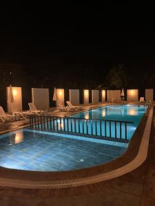 a large swimming pool at night with chairs and lights at Begonvil Life in Gazipasa