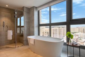 un bagno con vasca e ampia finestra di Marriott Executive Apartments Doha, Le Mirage City Walk a Doha