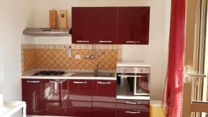 a kitchen with red cabinets and a stove top oven at Nice Home Pizzo in Pizzo