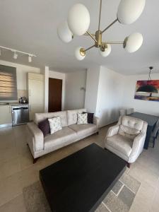 una sala de estar con un sofá y dos sillas en 2+1 in Cyprus Thalassa Beach Resort, en Vokolidha
